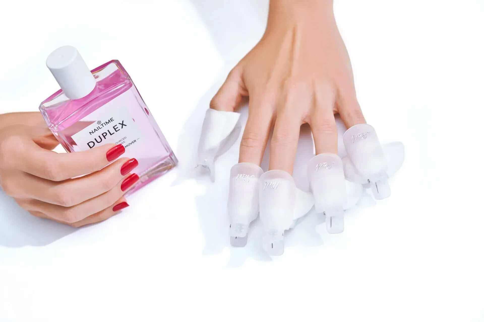 Nagellack Entfernung mit 💧 DUPLEX 💅🏻, Hände mit äußeren Schutzüberzügen und Pinkem Nagellack.