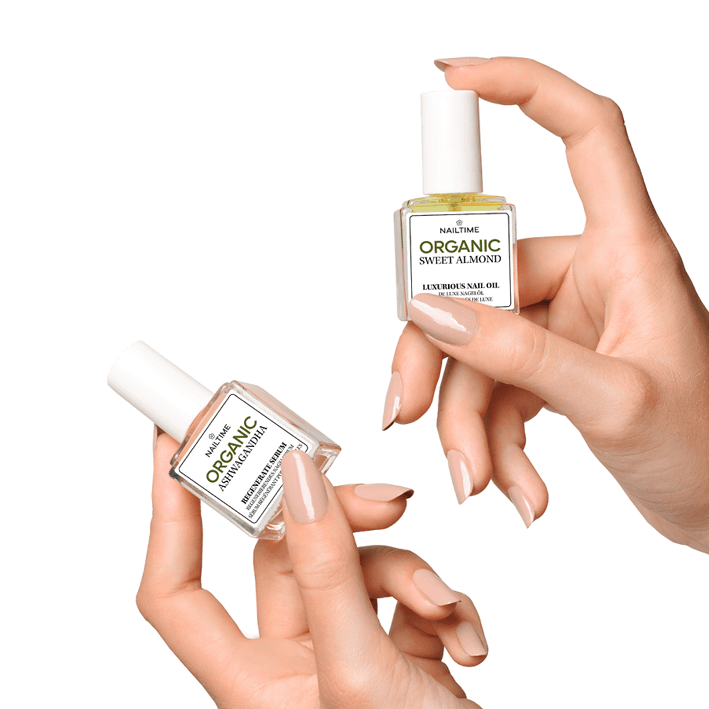 Hände halten zwei Fläschchen mit ORGANIC Nagelpflegeölen, einer mit indischem Ginseng und einer mit süßem Mandelnöl.