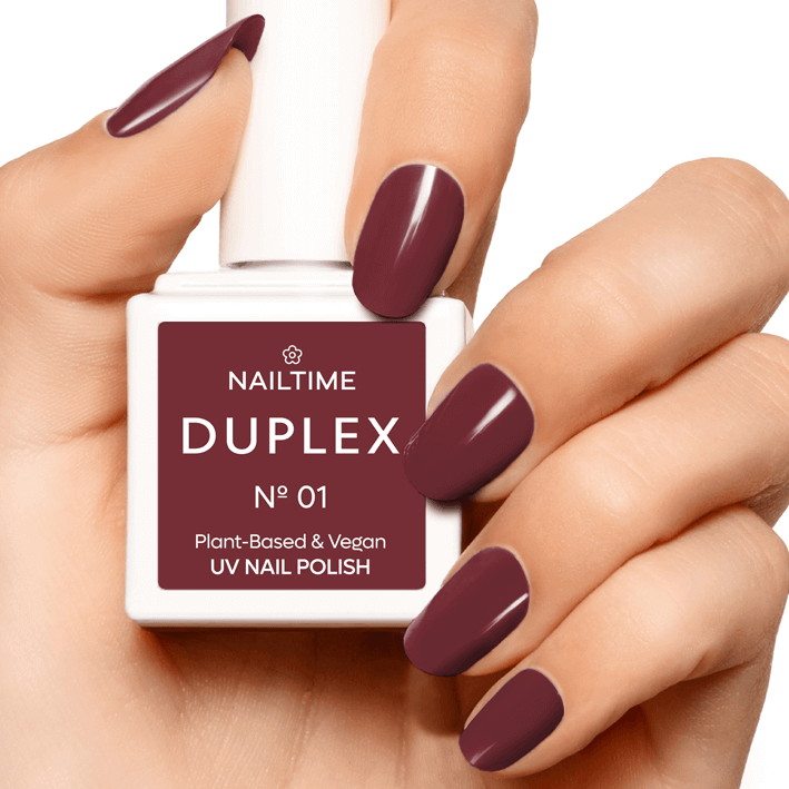 DUPLEX No.01 Love Red UV nail polish in a hand, showcasing its plant-based and vegan formula.