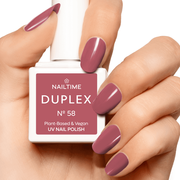 DUAL NAIL POLISH No.58 Wild Romance in a hand, showcasing a warm rose color, plant-based, vegan, and UV-drying.