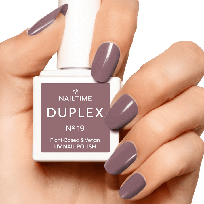 DUPLEX No.19 Soulbreaker plant-based UV nail polish in soft rose-lilac shade held by manicured hand.