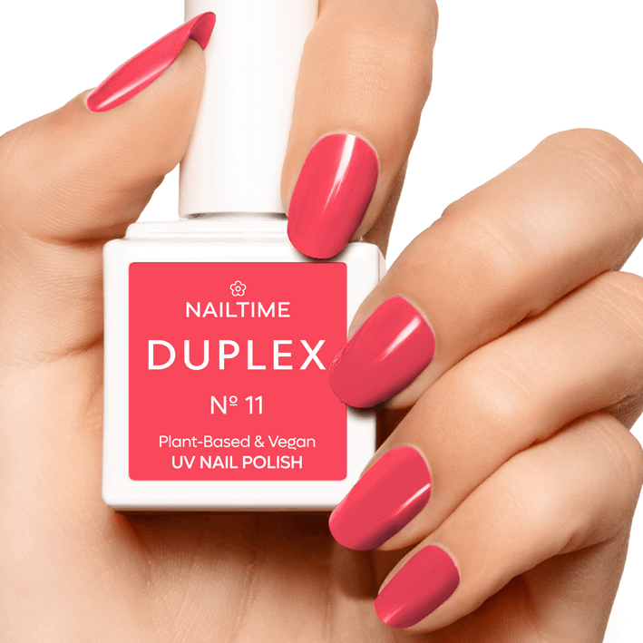 DUPLEX No.11 Hollywood Red vegan nail polish in a hand, showcasing coral shade and plant-based ingredients.